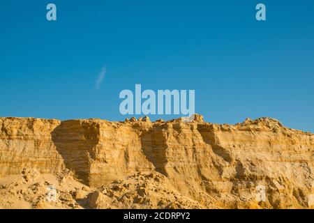 Klippe der gelb orange braun Sand Boden Ton unter den sonnigen Tag mit tiefblauen Himmel Stockfoto