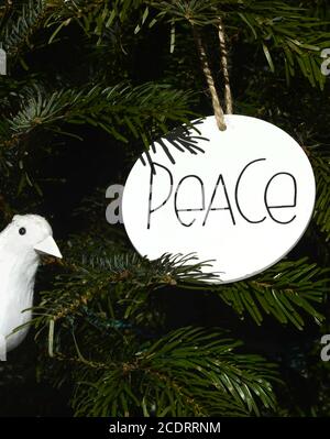 Ornamente, einschließlich einer weißen Taube und Friedenszeichen, schmücken einen Weihnachtsbaum in den Vereinigten Staaten. Stockfoto