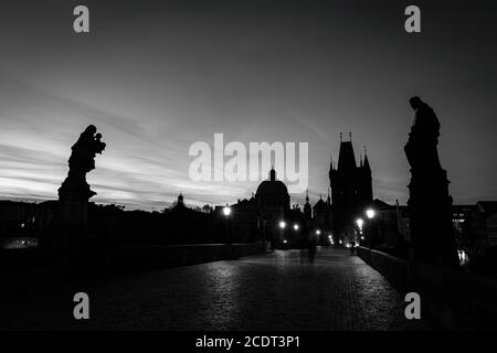 Karlsbrücke bei Sonnenaufgang, Prag, Tschechische Republik. Statuen, mittelalterliche Türme in schwarz und weiß Stockfoto