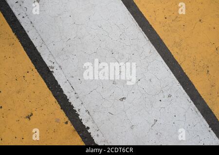 Asphalt Autobahn Textur mit gerissenen weißen und gelben Streifen Stockfoto