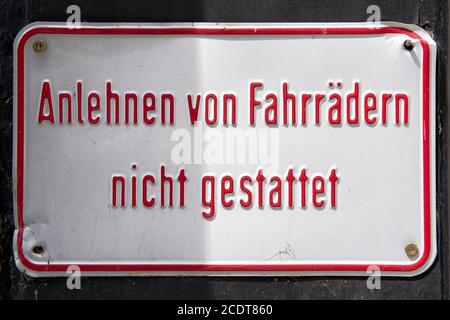 Schild an einer Hauswand mit der Inschrift Schiefen von Fahrräder nicht erlaubt Stockfoto