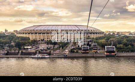 Moskau - 21. Aug 2020: Luzhniki Stadion und moderne Seilbahn in Moskau, Russland. Seilbahnkabinen hängen bei Sonnenuntergang über dem Moskva Fluss. Es ist das Wahrzeichen von Mo Stockfoto