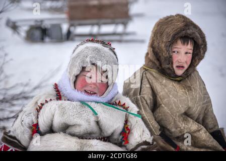 Junge Nenet Mädchen und Jungen auf einem Schlitten sitzen mit traditionellen Kleidern, Yamalo-Nenets Autonomen Okrug, Russland Stockfoto