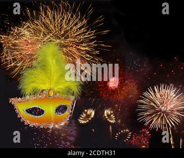 Buntes Feuerwerk am schwarzen Nachthimmel und Maske mit Federn Stockfoto