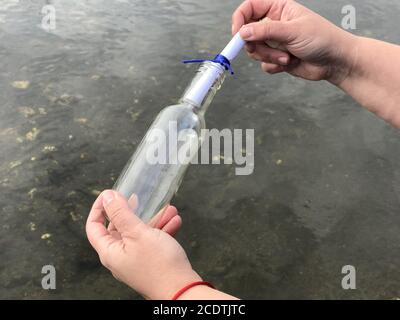 Eine Person mit einer Botschaft in einer Kristallflasche Stockfoto