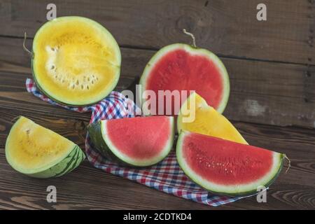 Schneiden Sie rote und gelbe Wassermelonen auf einem hölzernen Kasten in einem vintage Holz- Hintergrund im rustikalen Stil, selektiver Fokus, getönten Foto. Stockfoto