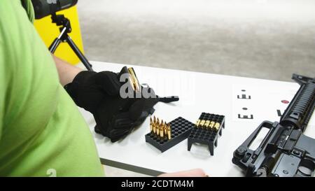 Erwachsene, die ein Sturmgewehr auf einem Schießstand laden Stockfoto