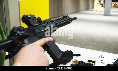 Erwachsene, die ein Sturmgewehr auf einem Schießstand laden Stockfoto
