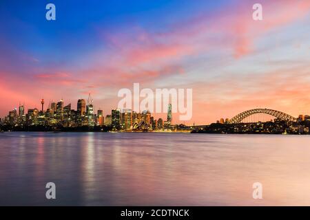 Spektakulärer, farbenfroher Sonnenuntergang über der Skyline von Sydney und den Hafengewässern. Stockfoto
