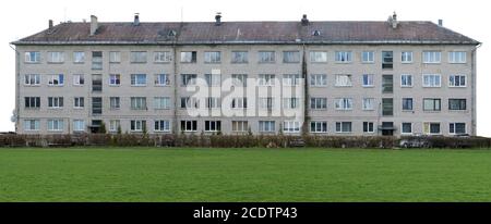 Grüner Rasen in der Nähe des alten einstürzenden Gebäudes Stockfoto