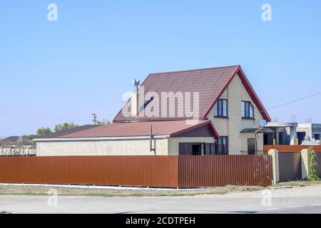 Haus mit Kunststoff Fenster und Dach aus Wellblech. Dächer aus Metall Profil wellige Form auf dem Haus mit Kunststofffenster Stockfoto