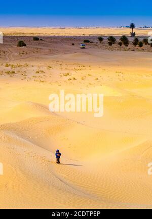 Kind in der Sahara spielt mit dem Sand der Dünen, Tourist im Urlaub Stockfoto