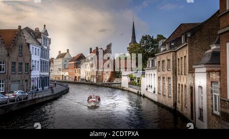 Kanalbootfahrt auf dem Kanal St. Annarei in der historischen Stadt Brügge, Belgien mit der Skulptur Lanchals aus Stahl und dem Turm der St. Anna Kirche Stockfoto