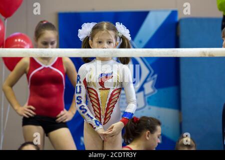 Moskau, Russland. 26. Oktober 2013 EINE junge Turnerin vor der Durchführung auf den unebenen Bars in einer Turnhalle in Moskau, Russland Stockfoto