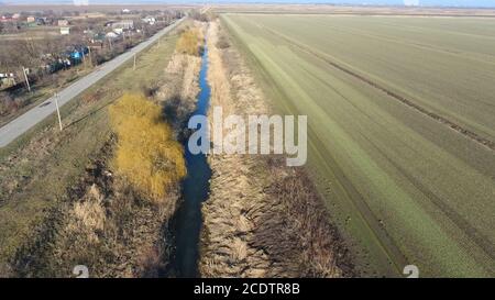 Der Kanal der unteren Ebene des Bewässerungssystems von Feldern. Infrastruktur für den Anbau von Reis Stockfoto