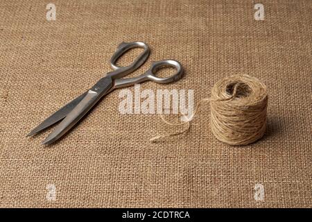 Alte Stahl Schneiderschere und Skein von Jute Seil auf Brauner Grass Stockfoto