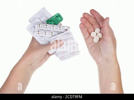 Eine alte kranke Frau hält Pillen in ihren Händen, die bei der Verabredung eines Arztes eingenommen werden müssen. Stockfoto