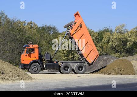 Der Muldenkipper entlädt Schutt. Der LKW hat die Ladung abgeladen. Sand und Kies. Bau von Straßen Stockfoto