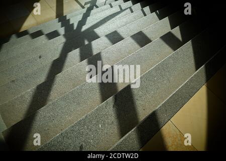 Schatten eines Fenster Gitter auf den Stufen einer Treppe Stockfoto