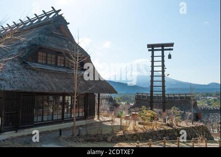 Reetdachhaus mit Glocke daneben im alten japanischen Dorf Saiko Iyashino-Sato Nenba (Heildorf). Stockfoto