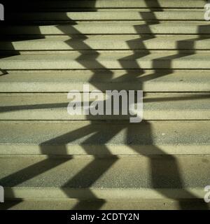 Schatten eines Fenstergrills auf der Treppe in einem Treppe Stockfoto