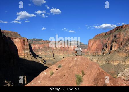 Junger Mann, der am sonnigen Sommernachmittag vom Thunder River Trail am Nordrand des Grand Canyon National Park aus den Blick auf den Grand Canyon genießt. Stockfoto