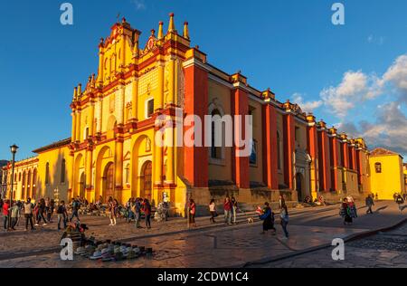 Mexikanisches Stadtleben mit Straßenverkäufern und Menschen an der Kathedralenfassade bei Sonnenuntergang, San Cristobal de las Casas, Mexiko. Stockfoto