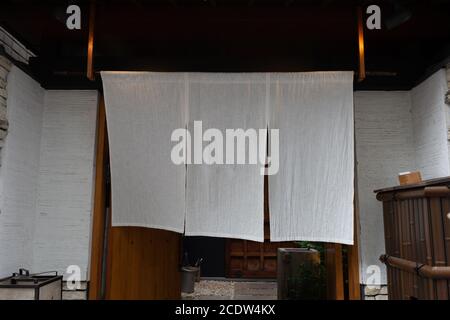 Der Vorhang-ähnliche Stoff, der vor traditionellen japanischen Restaurants und Geschäften hängt, dient nicht nur als Schild, sondern hat eine größere Bedeutung, Stockfoto