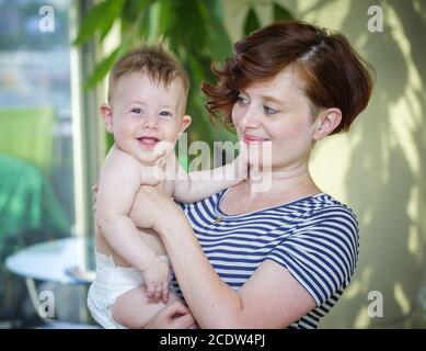 Mutter hält ihr 6 Monate altes Baby Stockfoto