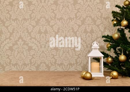 Dekorative Laterne am Weihnachtsbaum mit goldenen Kugeln, auf dem Velours vor dem Hintergrund von zarten Tapeten. Stockfoto