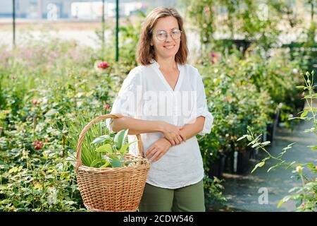 Heiter reif Brünette weibliche Arbeiter von Treibhaus oder Gärtner in casualwear Stockfoto