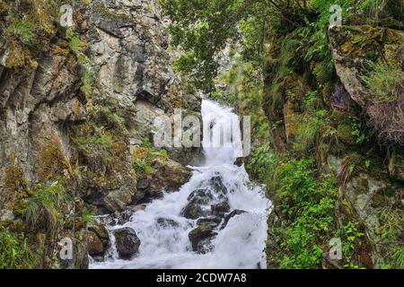 Bergwasserfall unter Felsen unter Felsbrocken im Altai-Gebirge, Russland Stockfoto