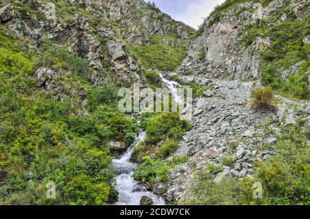 Bergbach fließt unter Klippen der Schlucht unter Felsbrocken im Altai-Gebirge, Russland Stockfoto