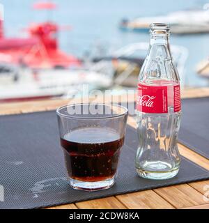 Coca-Cola-Flasche und ein Glas auf dem Tisch eines Strandbar der Stadt Vrsar in Kroatien Stockfoto