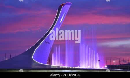 Sotschi, Russland - Mai 29. 2018. Schale der olympischen Flamme Firebird und Brunnen im olympischen Park am Abend Stockfoto