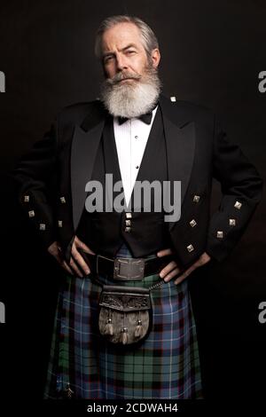 Reifes männliches Modell mit Kilt mit grauer Frisur und Bart Stockfoto