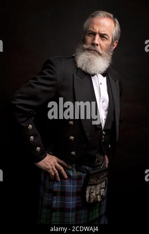 Reifes männliches Modell mit Kilt mit grauer Frisur und Bart Stockfoto