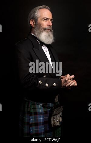 Reifes männliches Modell mit Kilt mit grauer Frisur und Bart Stockfoto