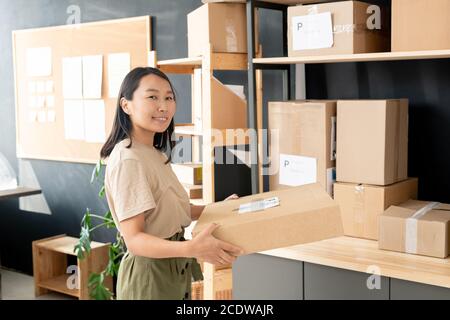 Lächelnder Jugendlicher der Post oder des Lagerraums, der Ordnung trägt Des Kunden Stockfoto