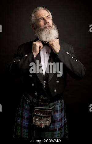 Reifes männliches Modell mit Kilt mit grauer Frisur und Bart Stockfoto