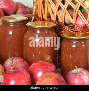 apfelmarmelade in Gläsern und viele frische Äpfel Stockfoto