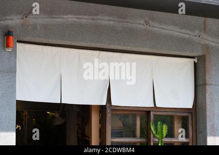 Der Vorhang-ähnliche Stoff, der vor traditionellen japanischen Restaurants und Geschäften hängt, dient nicht nur als Schild, sondern hat eine größere Bedeutung, Stockfoto