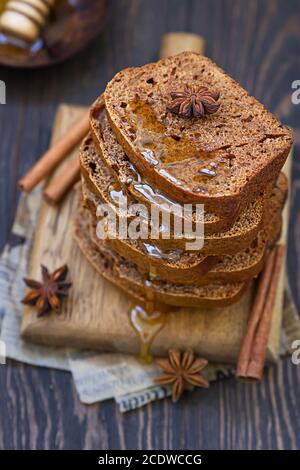 Lebkuchen und Honigkuchen mit Zimt und Anis auf dunklem Holzhintergrund. Rustikaler Stil. Stockfoto