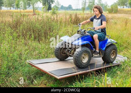 Junger europäischer Mann fährt Quad auf Balance Stockfoto