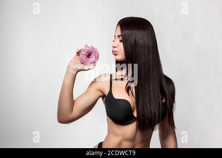 Beauty fashion model Mädchen unter bunten Donuts Stockfoto