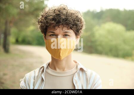 Zeitgenössische junge Brünette Frau in schützende handgemachte Maske Stockfoto