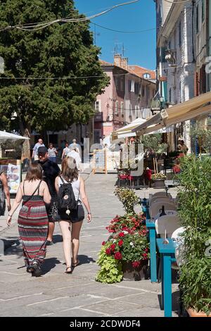 Touristen bei einem Spaziergang durch die historische Altstadt von Porec in Istrien in Kroatien Stockfoto