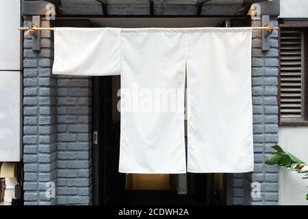 Der Vorhang-ähnliche Stoff, der vor traditionellen japanischen Restaurants und Geschäften hängt, dient nicht nur als Schild, sondern hat eine größere Bedeutung, Stockfoto