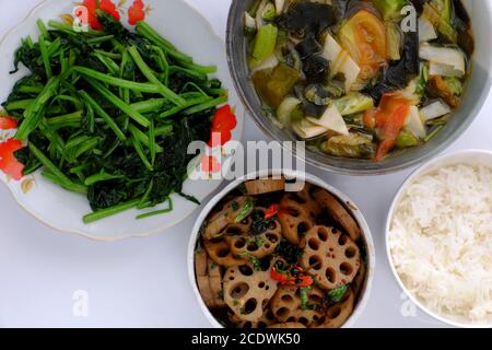 Vegane tägliche Mahlzeit, Lotuswurzel geschnitten Koch mit Sauce, Gemüsesuppe, Reisschüssel, gebratenen Spinat, einfache vegetarische vietnamesische Nahrung für die Ernährung Stockfoto