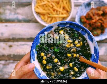 Frau Hand halten Seetang mit Maissuppe Schüssel für vegane Mahlzeit auf Lebensmittel Hintergrund, einfache vietnamesische vegetarische Gericht gut für die Gesundheit, Ernährung, lecker Stockfoto